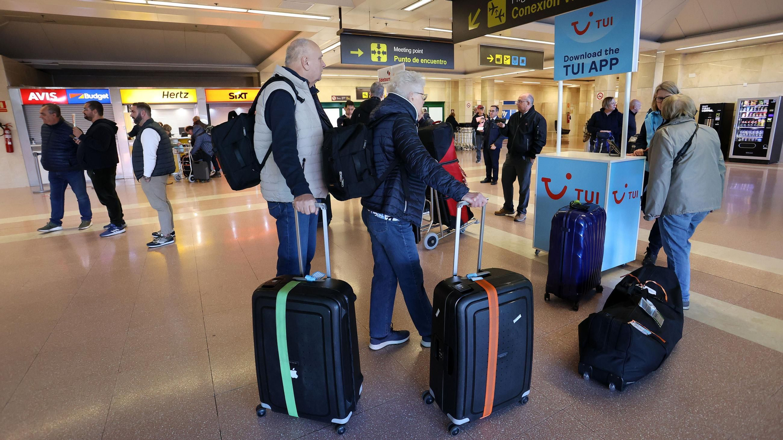 Pasajeros siendo atendidos por personal de un turoperador en la terminal de llegadas del Aeropuerto de Jerez.