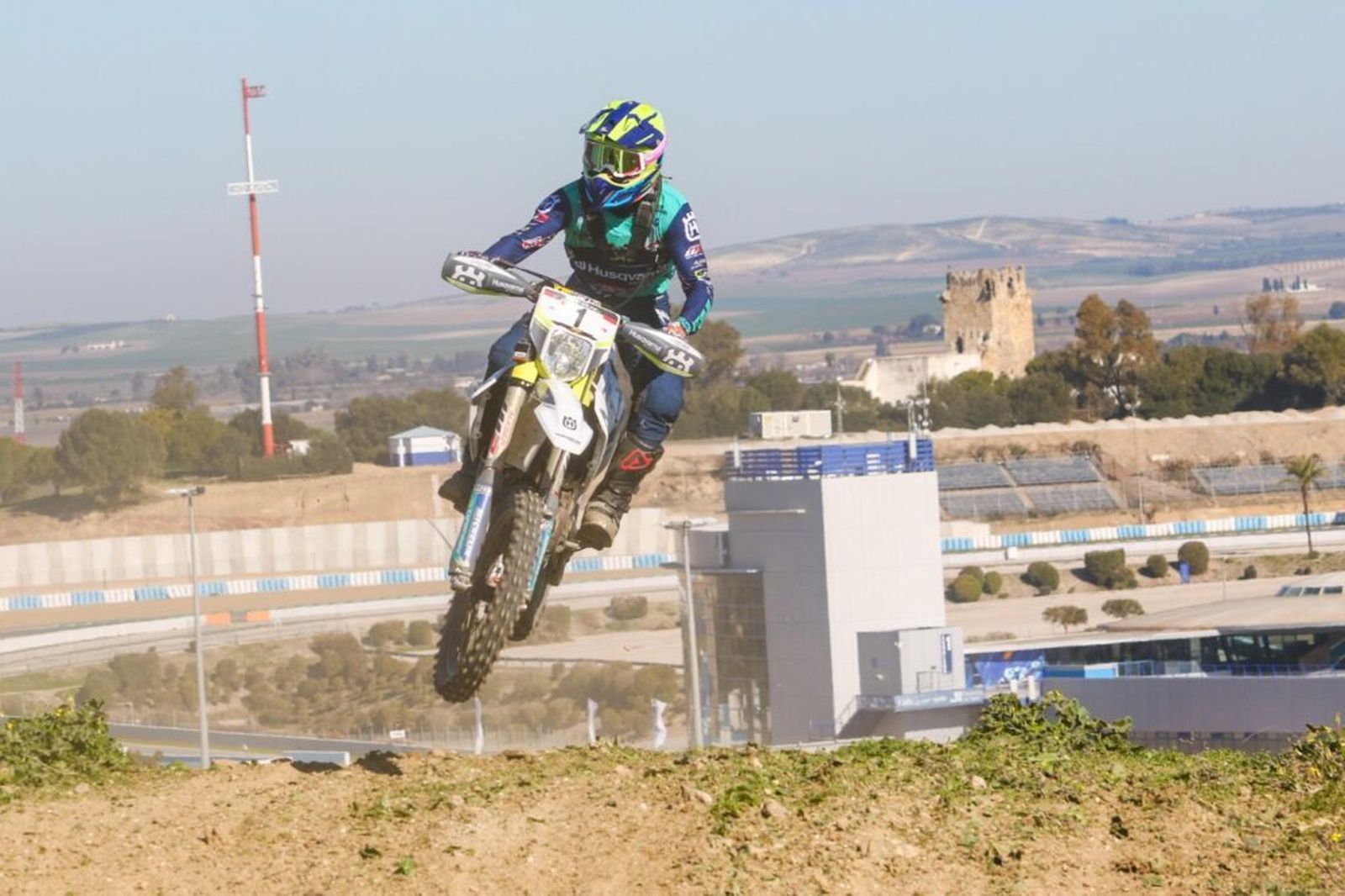 Sergio Navarro realiza un salto con el Circuito y la Torremelgarejo al fondo.