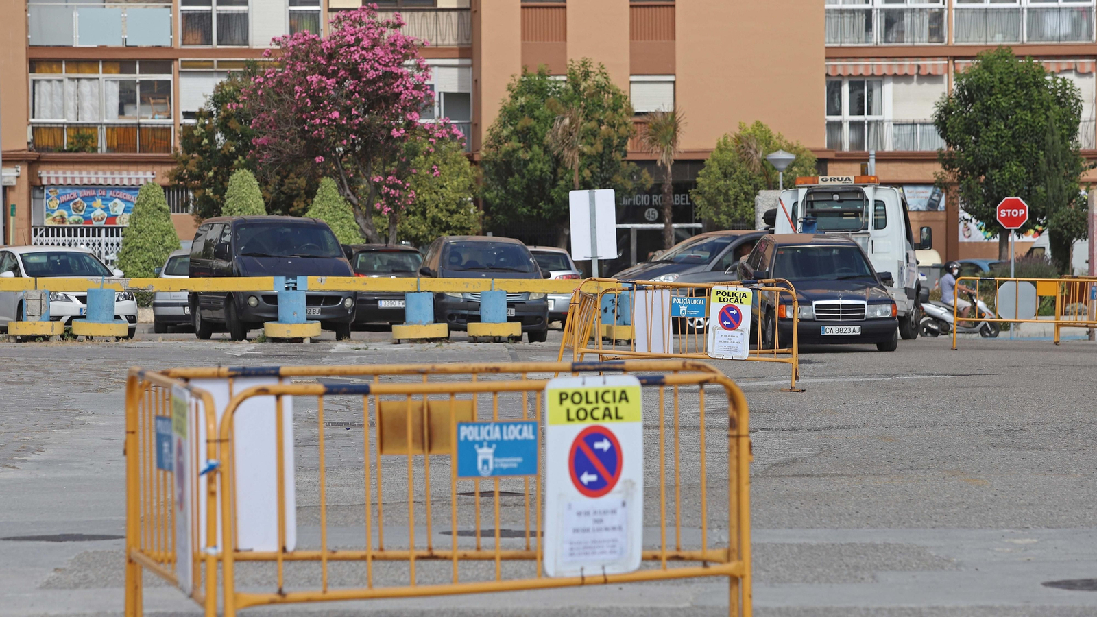 La grúa retira uno de los vehículos que seguían aparcados este domingo en el Llano Amarillo.