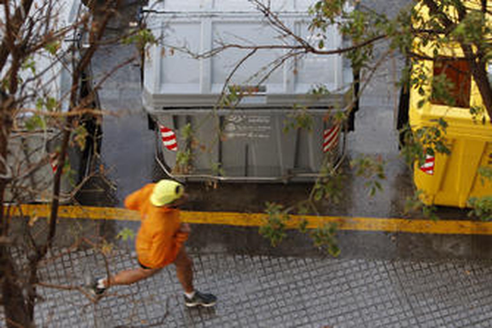 Un hombre pasa corriendo junto a varios contenedores. /José Braza