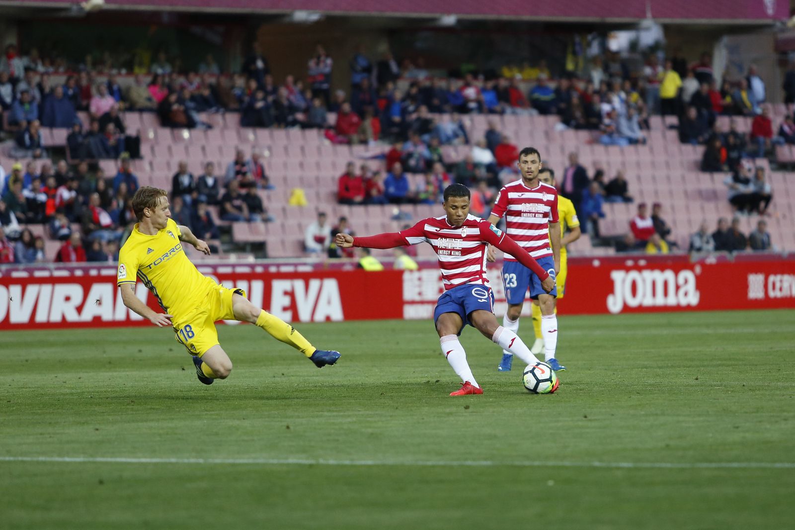 Machís golpea el balón ante Álex Fernández en el Granada-Cádiz de la pasada temporada.