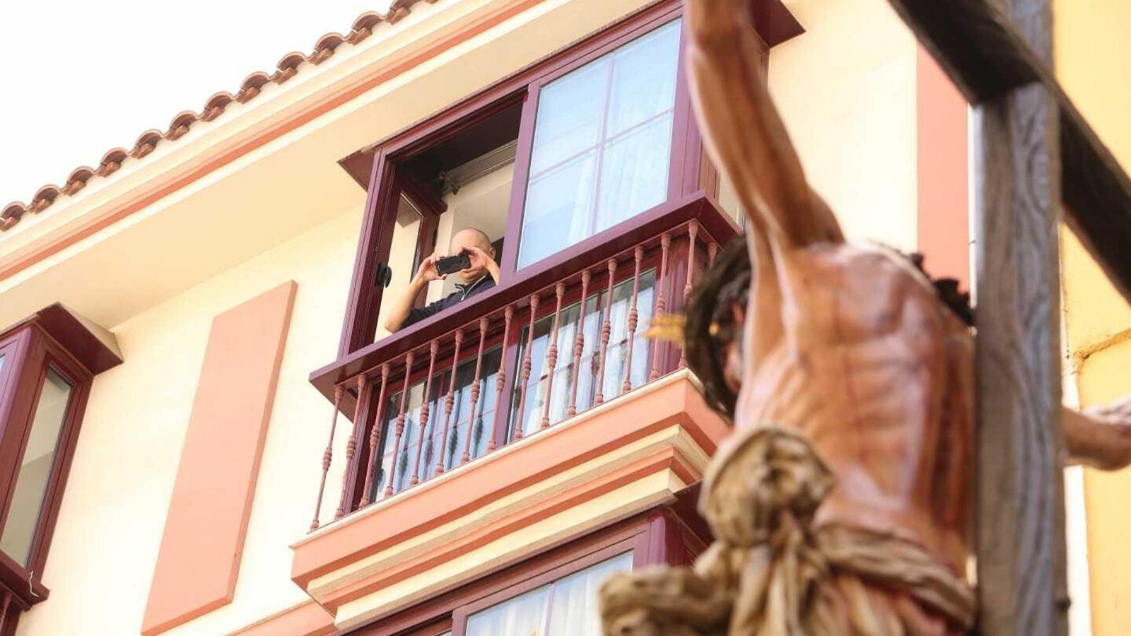 Un vecino fotografía al Cristo de la Crucifixión.