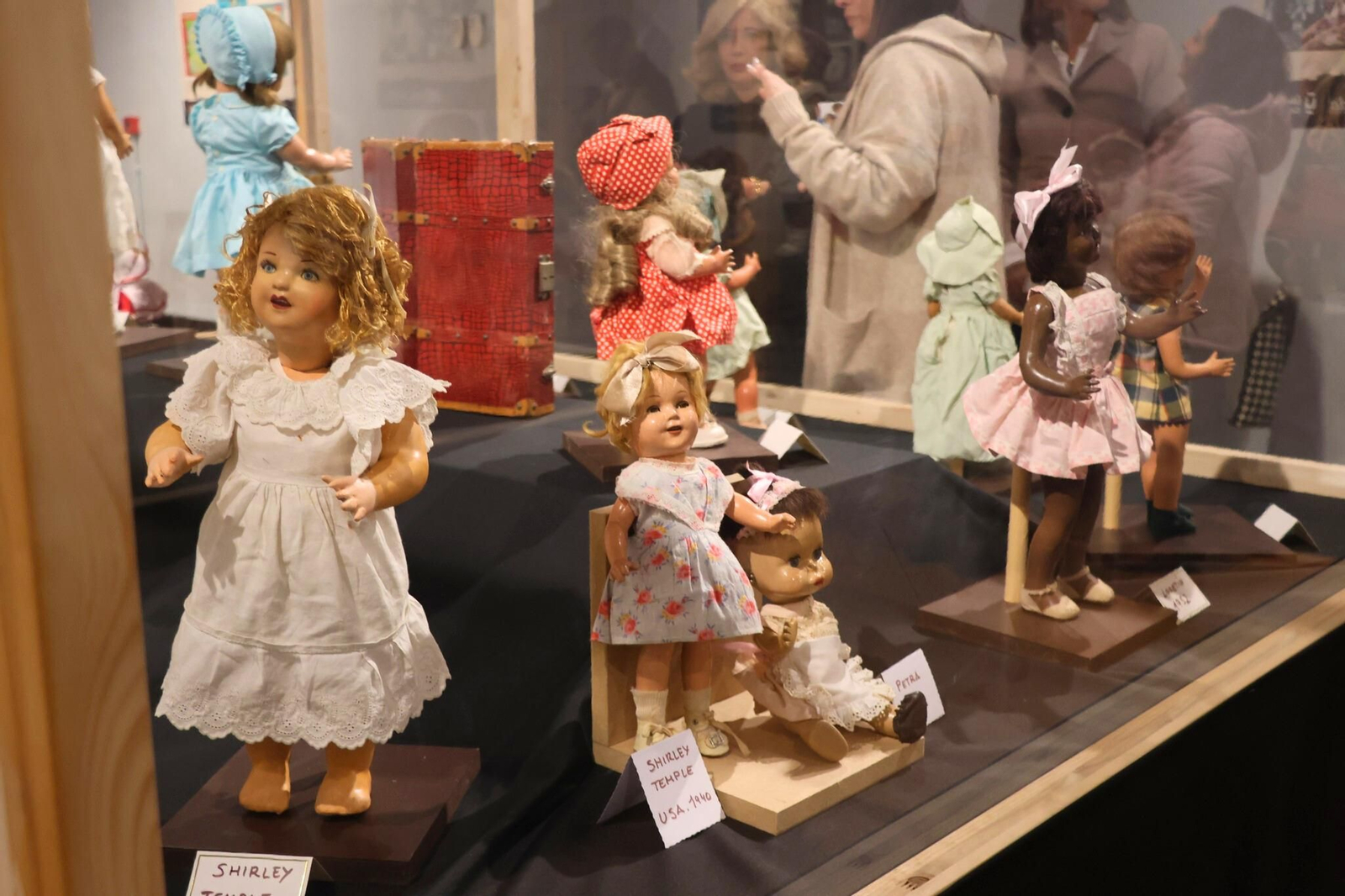 Escena expositiva con muñecas de distintas épocas y procedencias, que muestra la convivencia de estilos clásicos y contemporáneos ante la mirada del público.