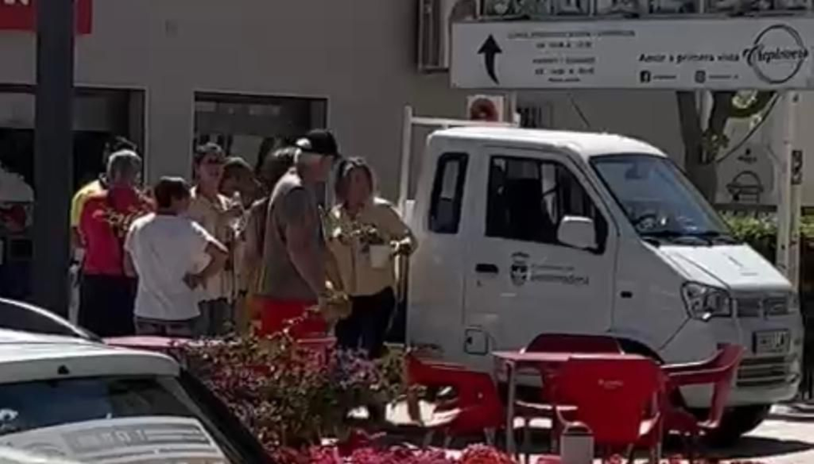 Una mujer portando unas macetas.
