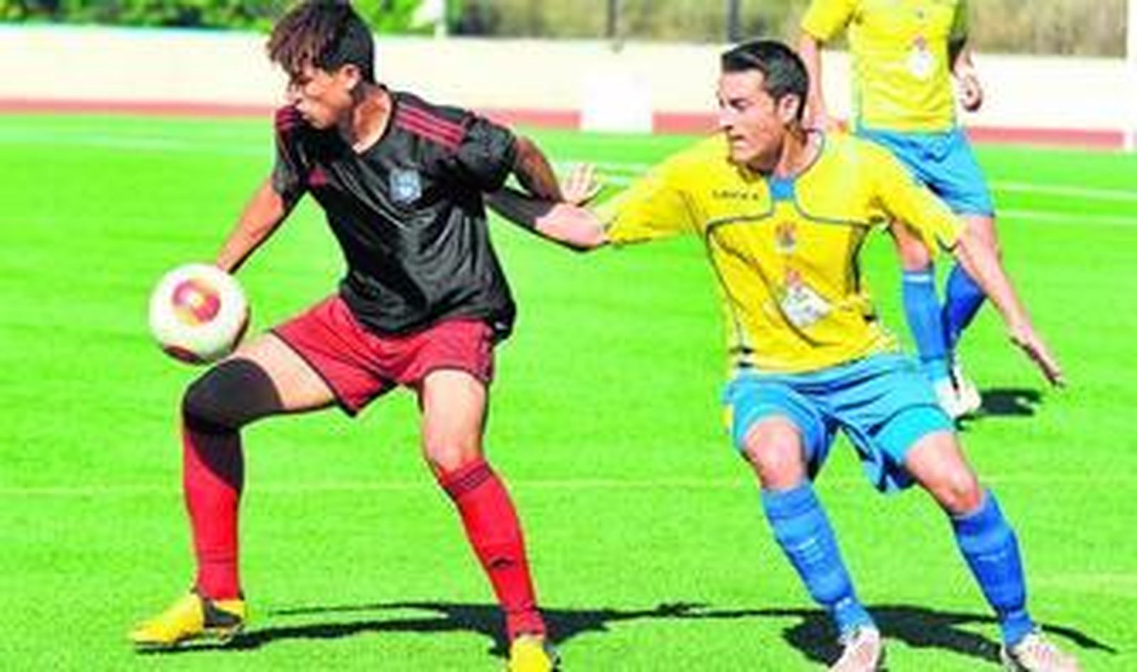 El sanjuanero Juan Carlos trata obstaculizar el control del balón de un jugador del Recreativo B.