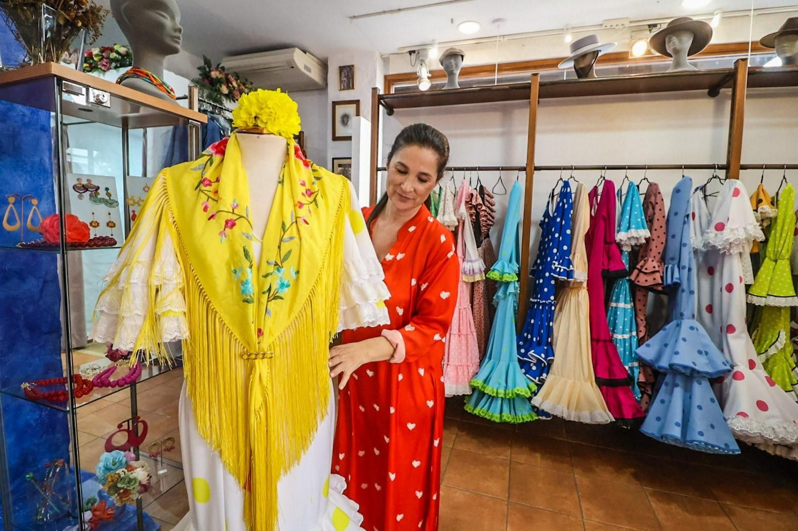 Conjunto de traje flamenco con mantoncillo y flor de la tienda El Ajolí.