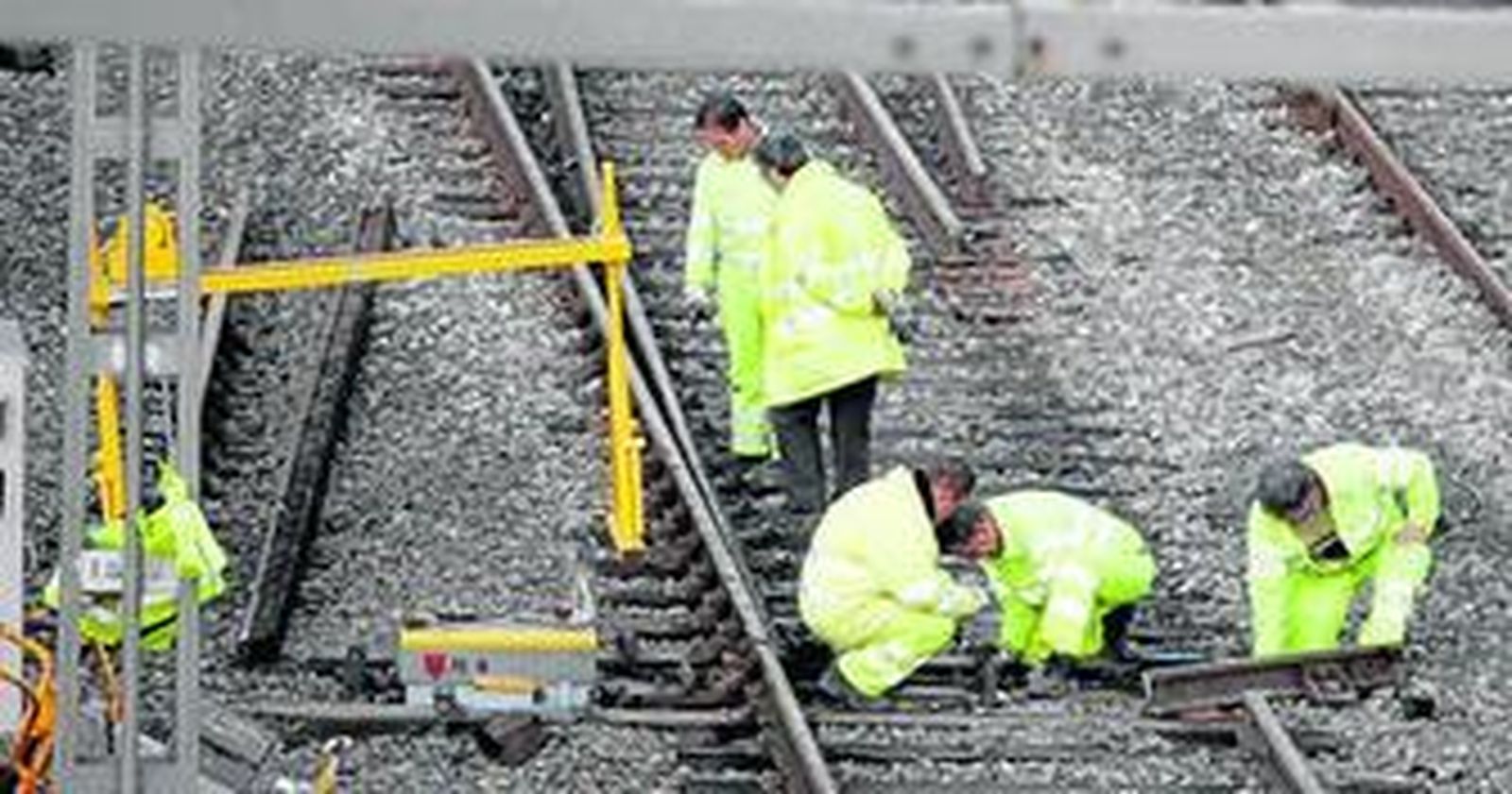 Operarios de Adif trabajan en las vías destrozadas por el tren que descarriló el domingo.