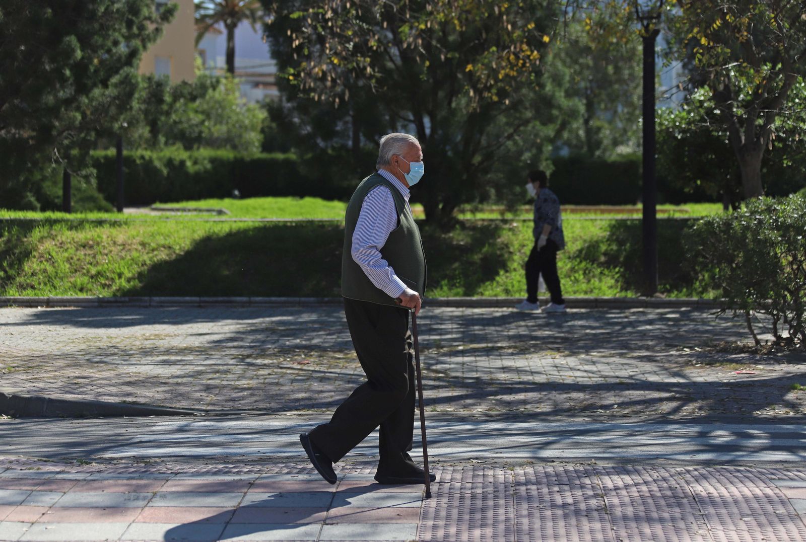 Una persona dependiente pasea sin compañía por el parque.
