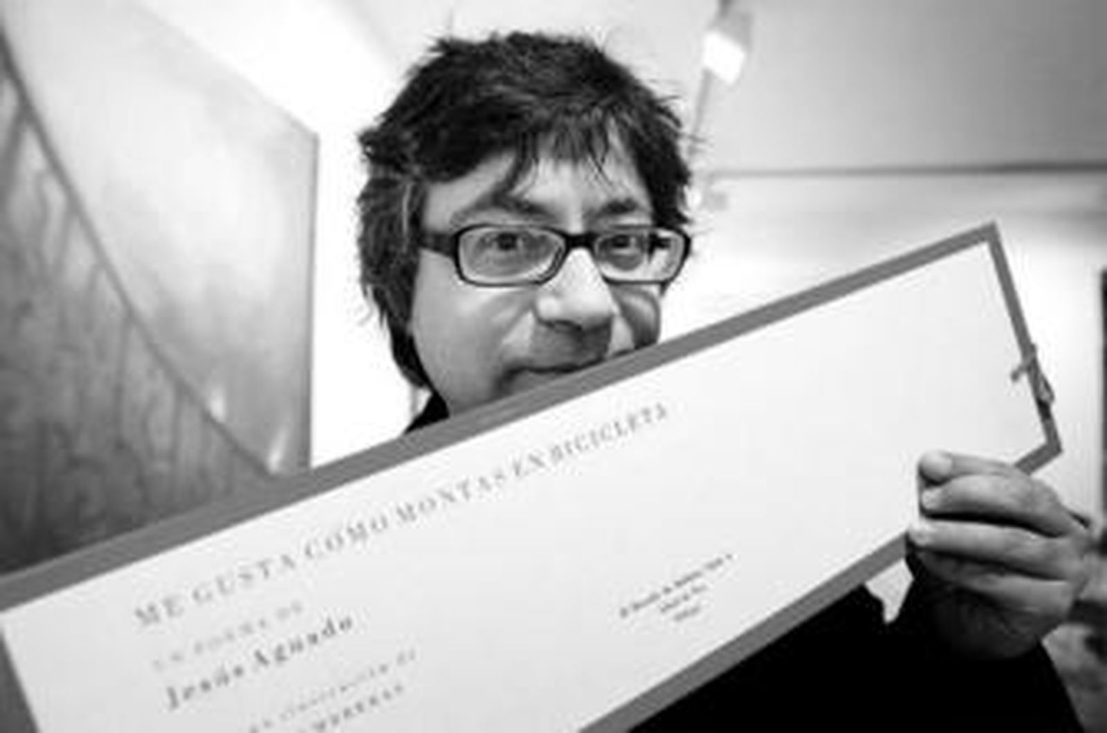 El poeta Jesús Aguado muestra la portada de su nuevo poemario, ayer, en la galería Alfredo Viñas.