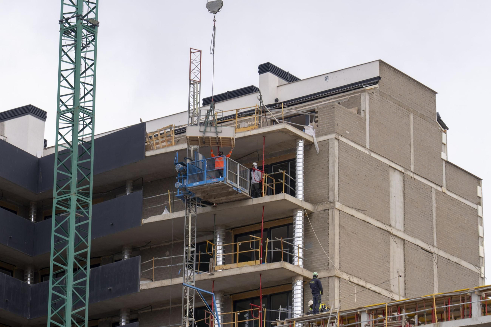 Varios obreros en un edificio de viviendas en construcción.