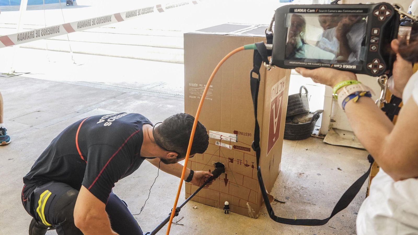 Un bombero enseña a una niña como usan la pértiga con cámara para localizar a posibles supervivientes en terremotos Un bombero enseña a una niña como usan la pértiga con cámara para localizar a posibles supervivientes en terremotos