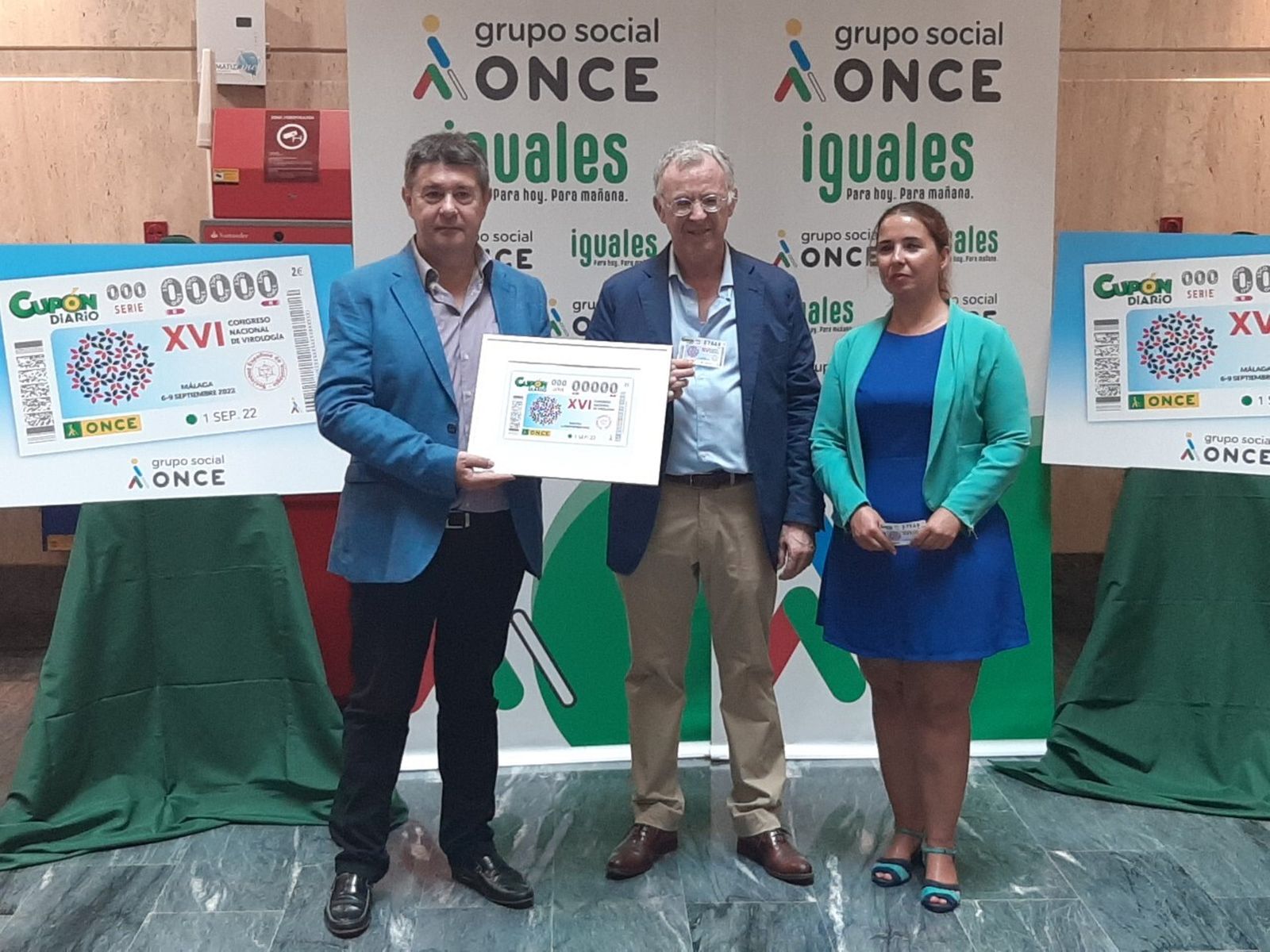 Responsables de la ONCE y del Congreso de Virología presentan el cupón.