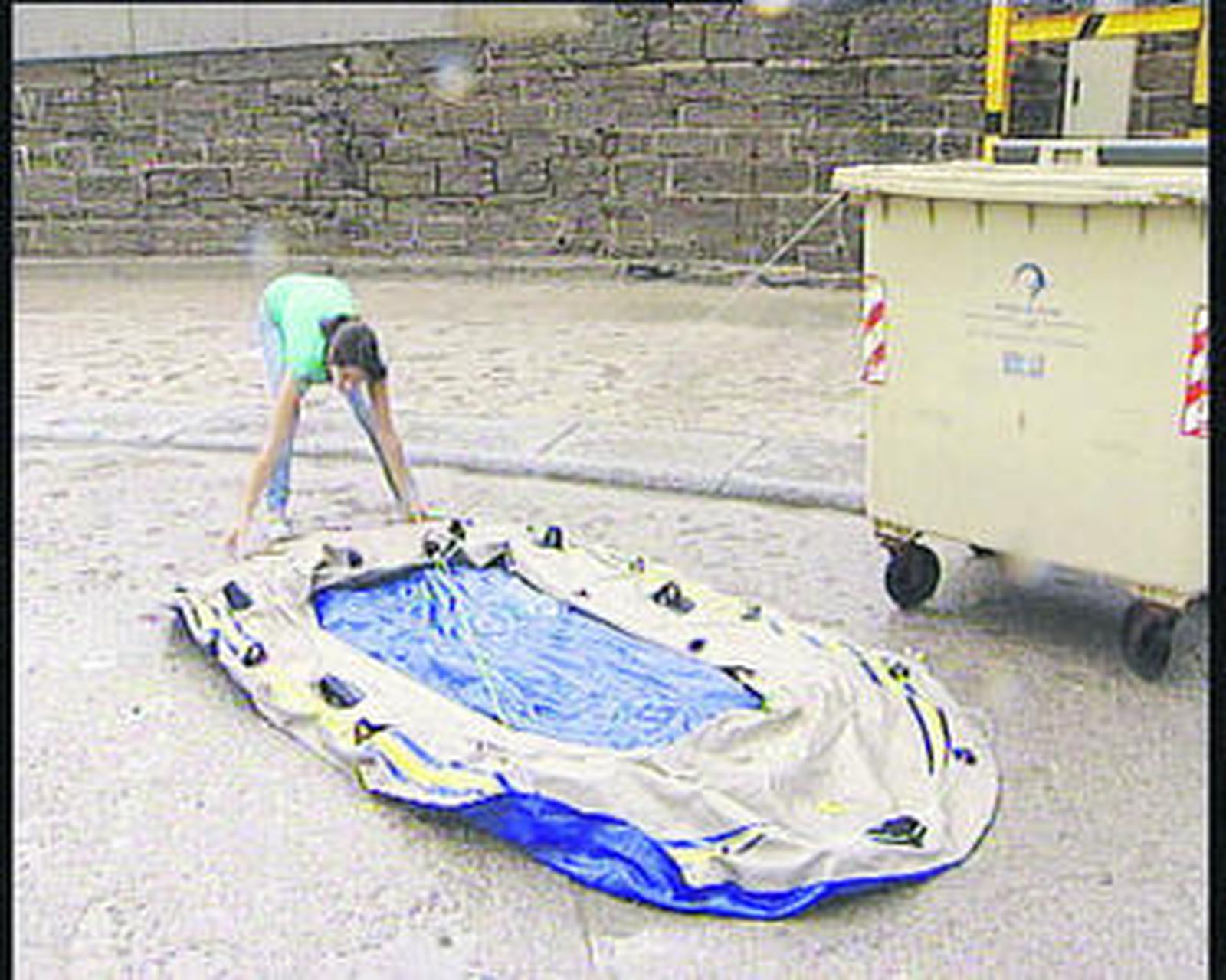 En la foto, una joven muestra el minúsculo tamaño de la balsa en la que llegaron los menores.