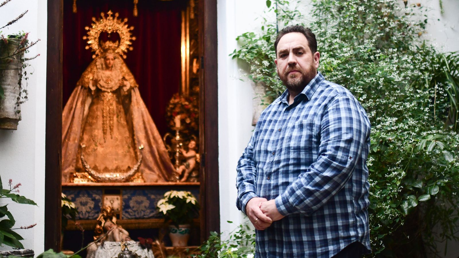 Rafael Barón posa junto a la capilla que tiene en su patio.