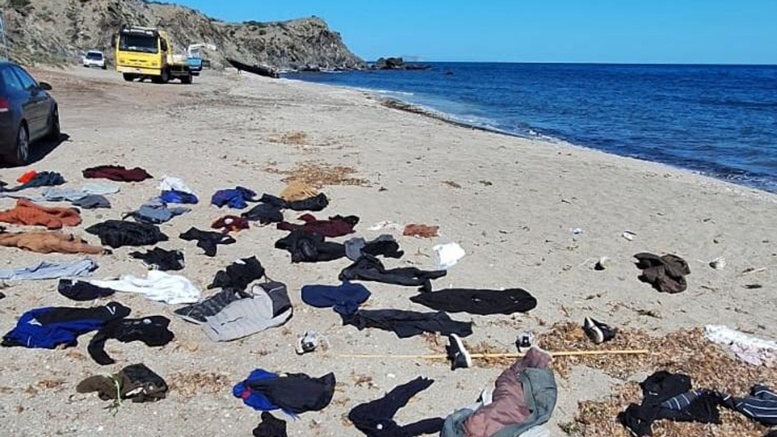Al llegar a tierra, algunos inmigrantes se cambian la ropa mojada en la playa