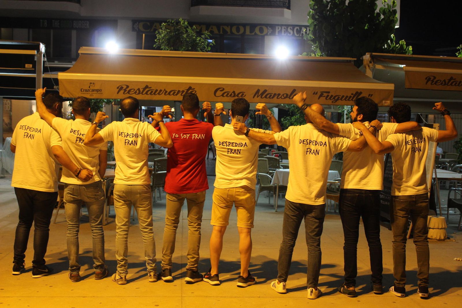 Un grupo de amigos hace una cadena en plena calle de Conil en una despedida de soltero. La foto es de este viernes por la noche.