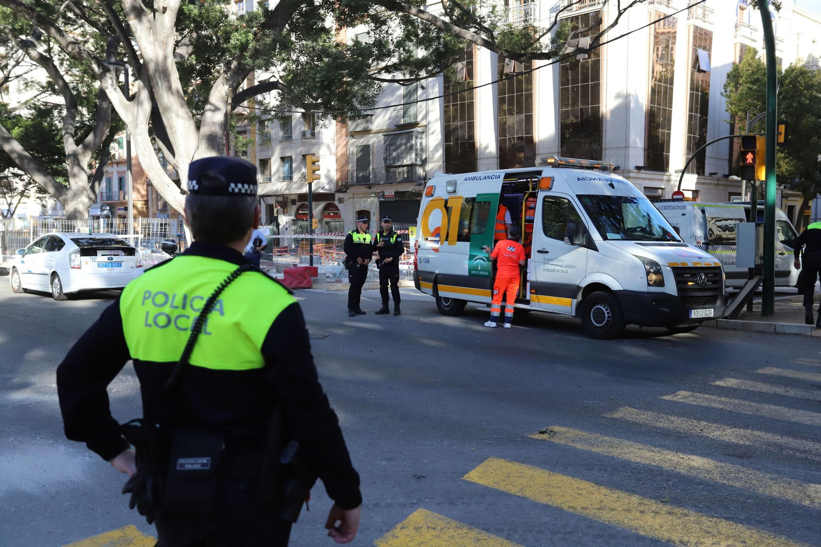Policías y sanitarios atienden un accidente en Málaga.