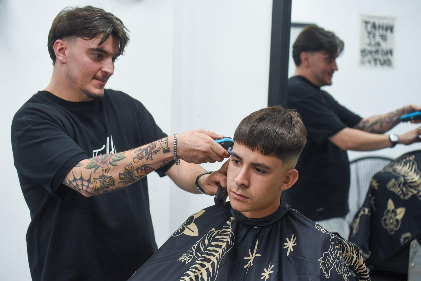 Fernando Campos le corta el pelo a un cliente en Fields Barber.