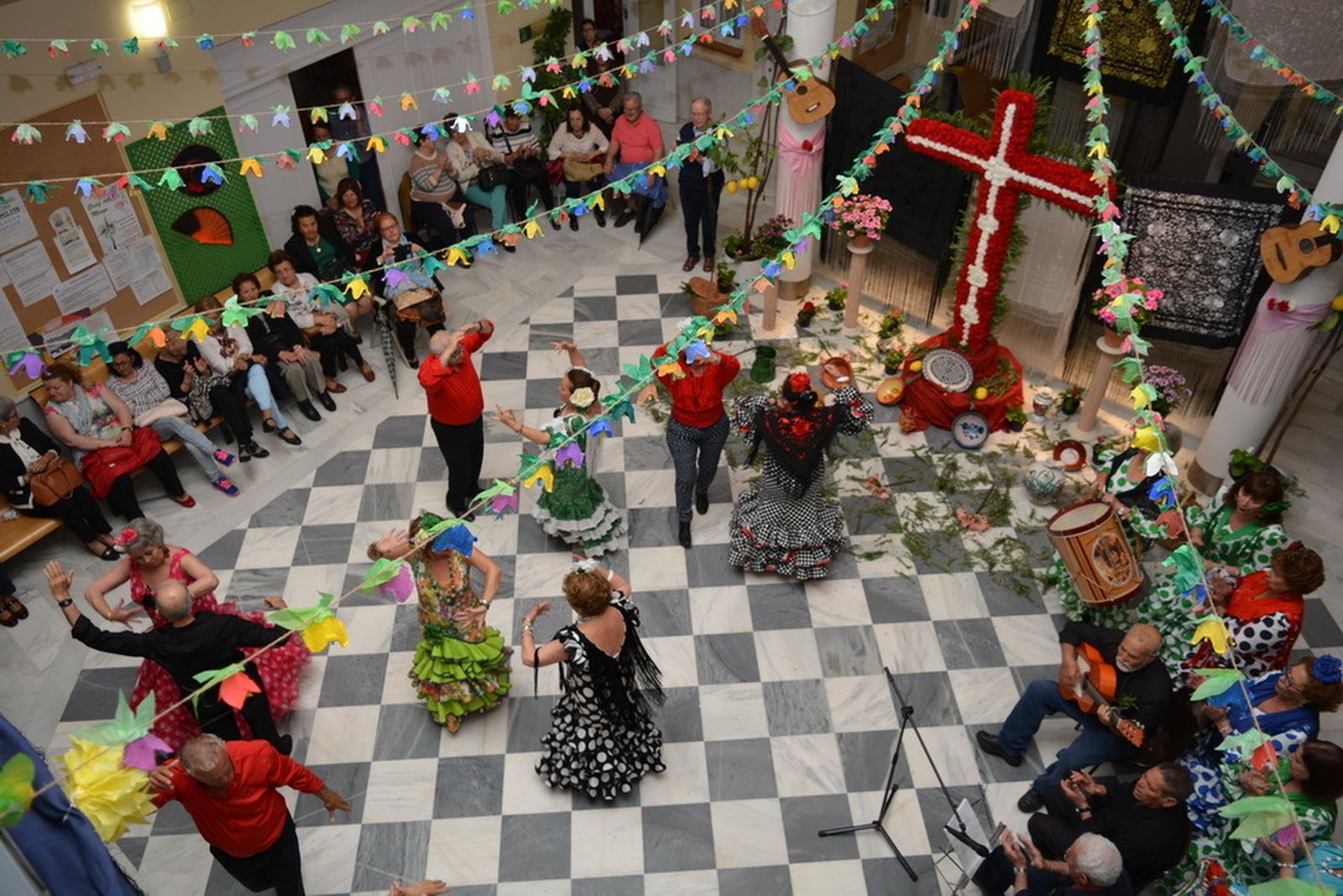 Unos mayores celebran una Cruz de Mayo en un Centro de Participación Activa.