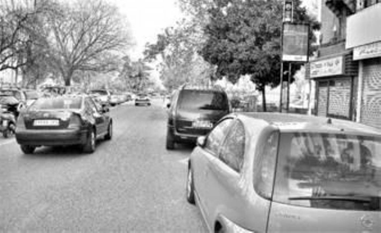 Varios vehículos aparcados en una parada de autobús de Carlos III.