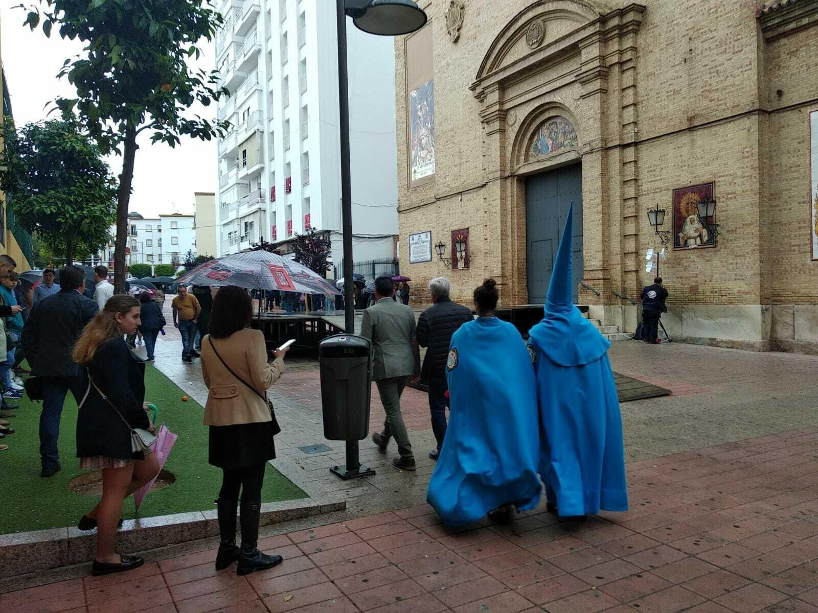 Dos penitentes de la Victoria se acercan al Sagrado Corazón.