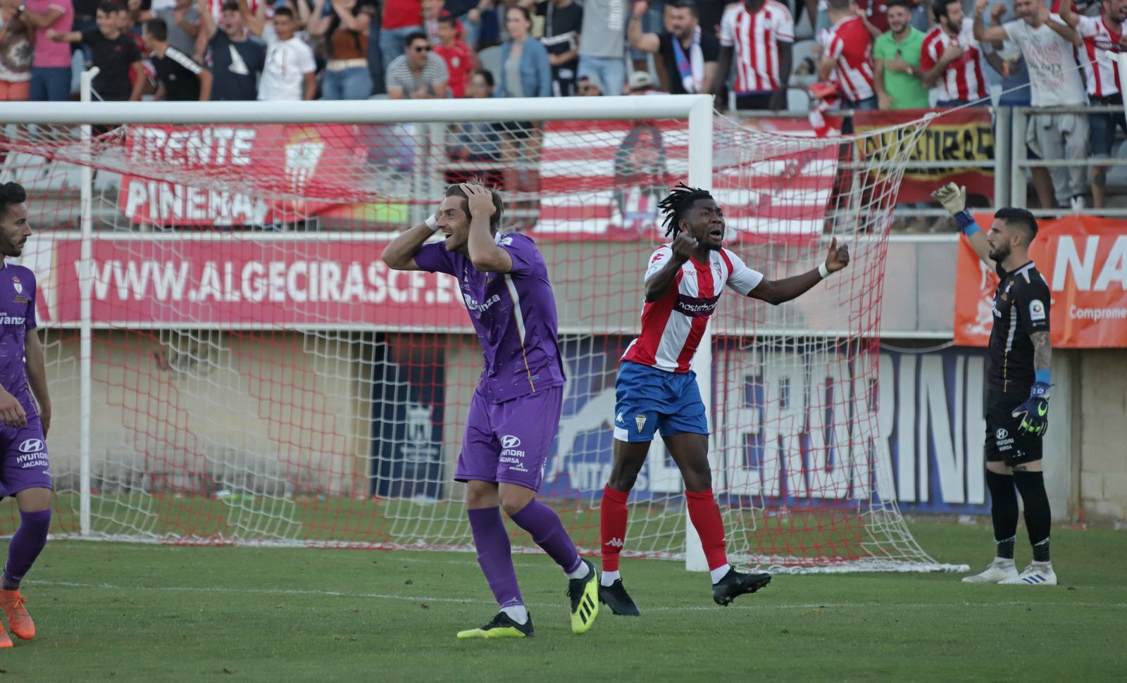 Javi Pérez se lleva las manos a la cabeza y Karim celebra en el penalti a favor del Algeciras.