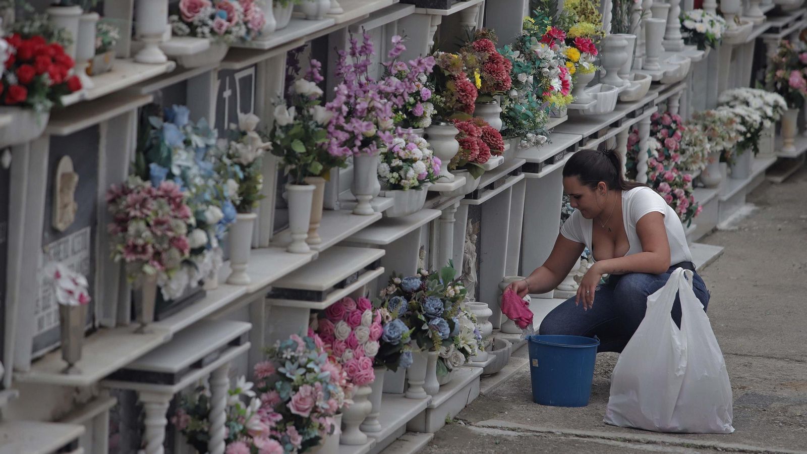 Una mujer, con los preparativos para Tosantos en el cementerio de Algeciras.