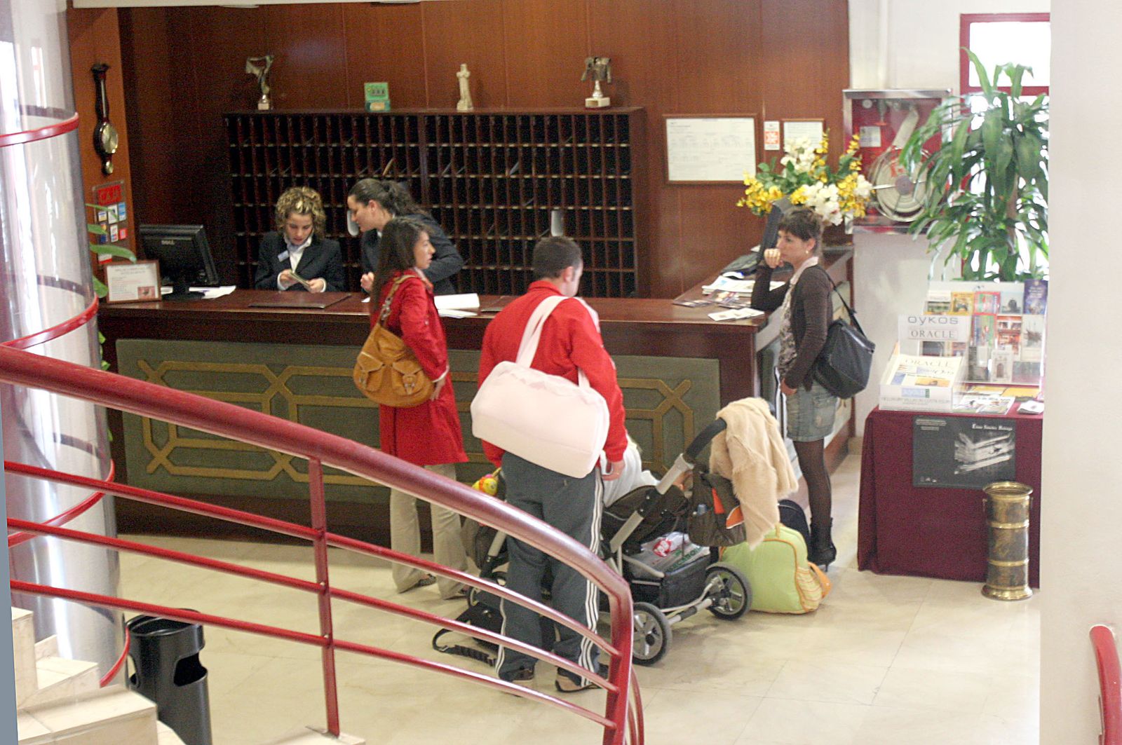 Turistas en la recepción de un establecimiento hotelero.