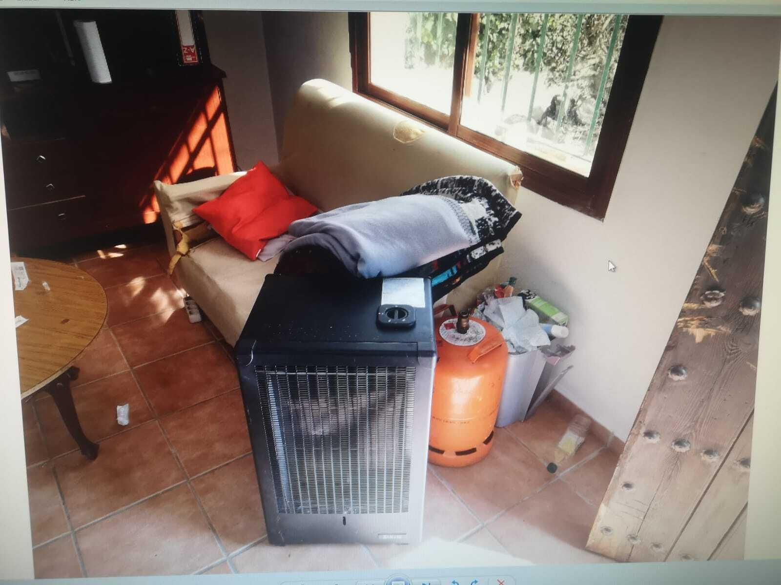 Estufa de gas junto a una de las bombonas encontradas