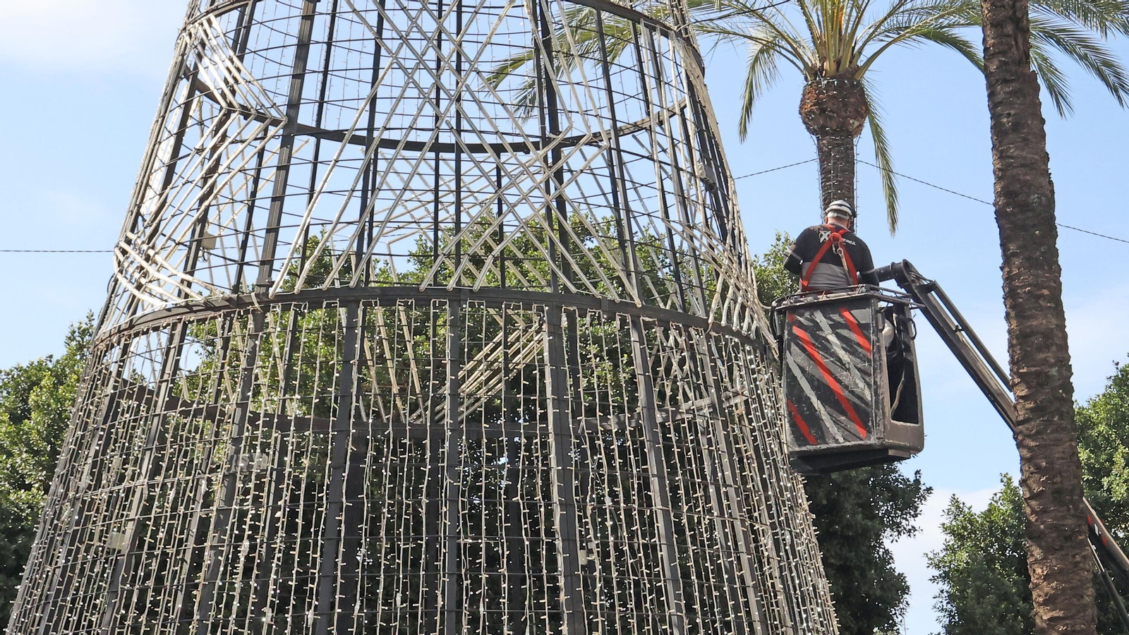 Operarios de Iluminaciones Ximénez, trabajando en el árbol de Navidad de la Plaza del Arenal.