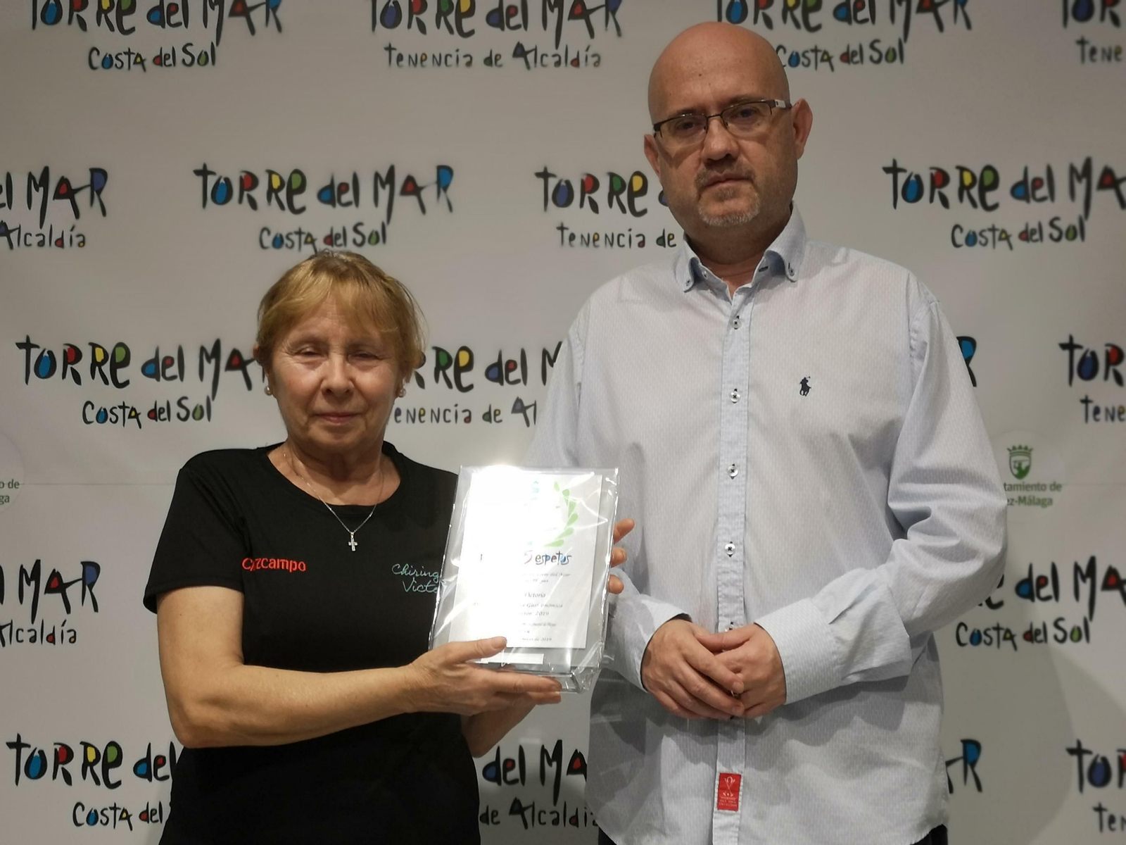 El concejal de Playas, Jesús Atencia, entregando el premio al mejor chiringuito a la dueña del chiringuito Victoria.