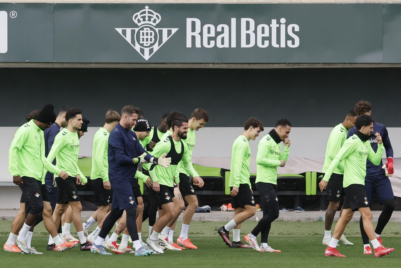Los jugadores del Betis se disponen a realizar carrera continua al inicio de un entrenamiento reciente en la ciudad deportiva verdiblanca en Los Bermejales.