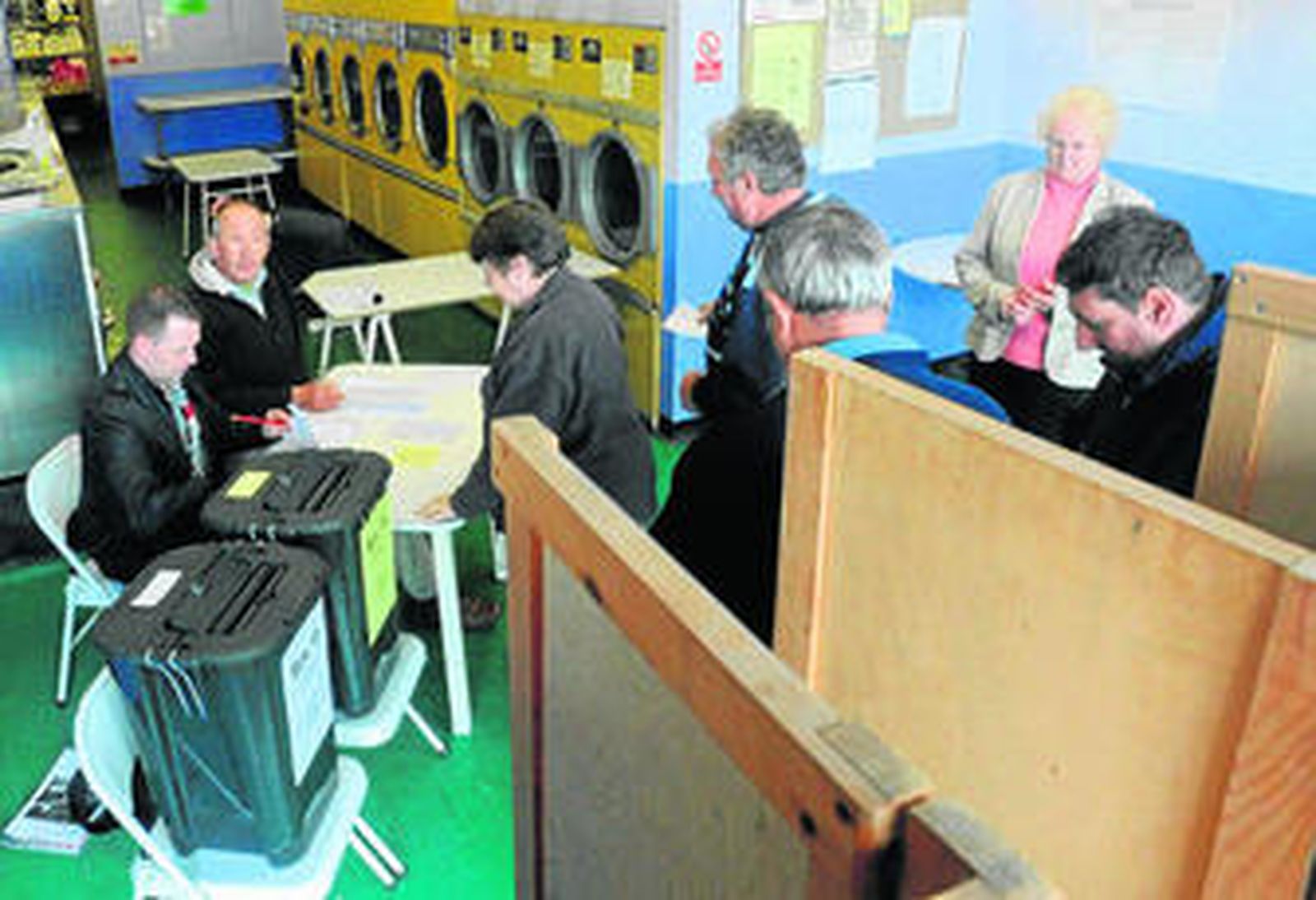 Varias personas esperan para votar en una lavandería de Oxford que a la vez es un local electoral.