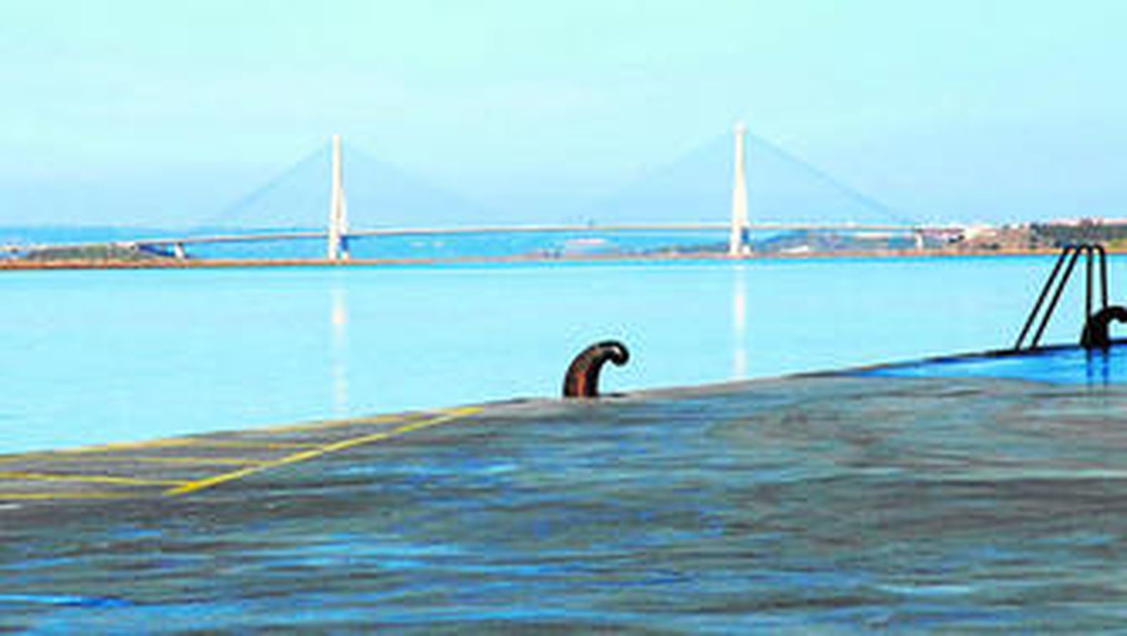 Muelle ayamontino con la vista al fondo del Puente Internacional del Guadiana, el primero que unió en 1991 a Huelva con Portugal.