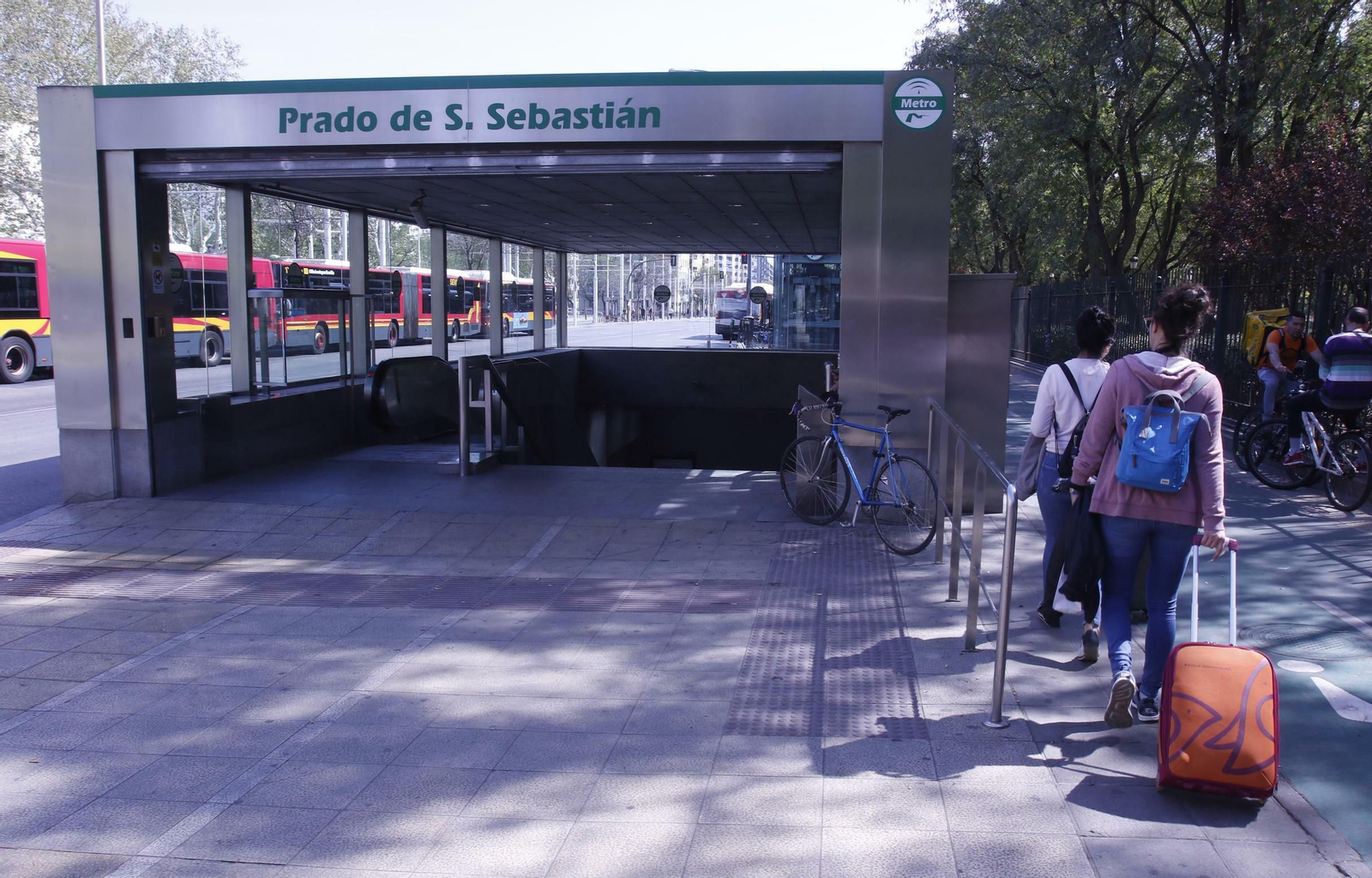Varios jóvenes con maletas junto a la estación del Metro del Prado.