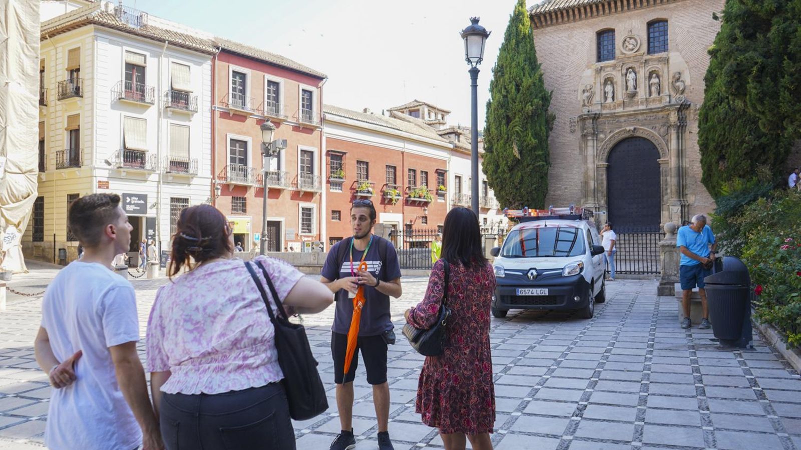 Unos turistas atienden a las explicaciones de un guía en Plaza Nueva