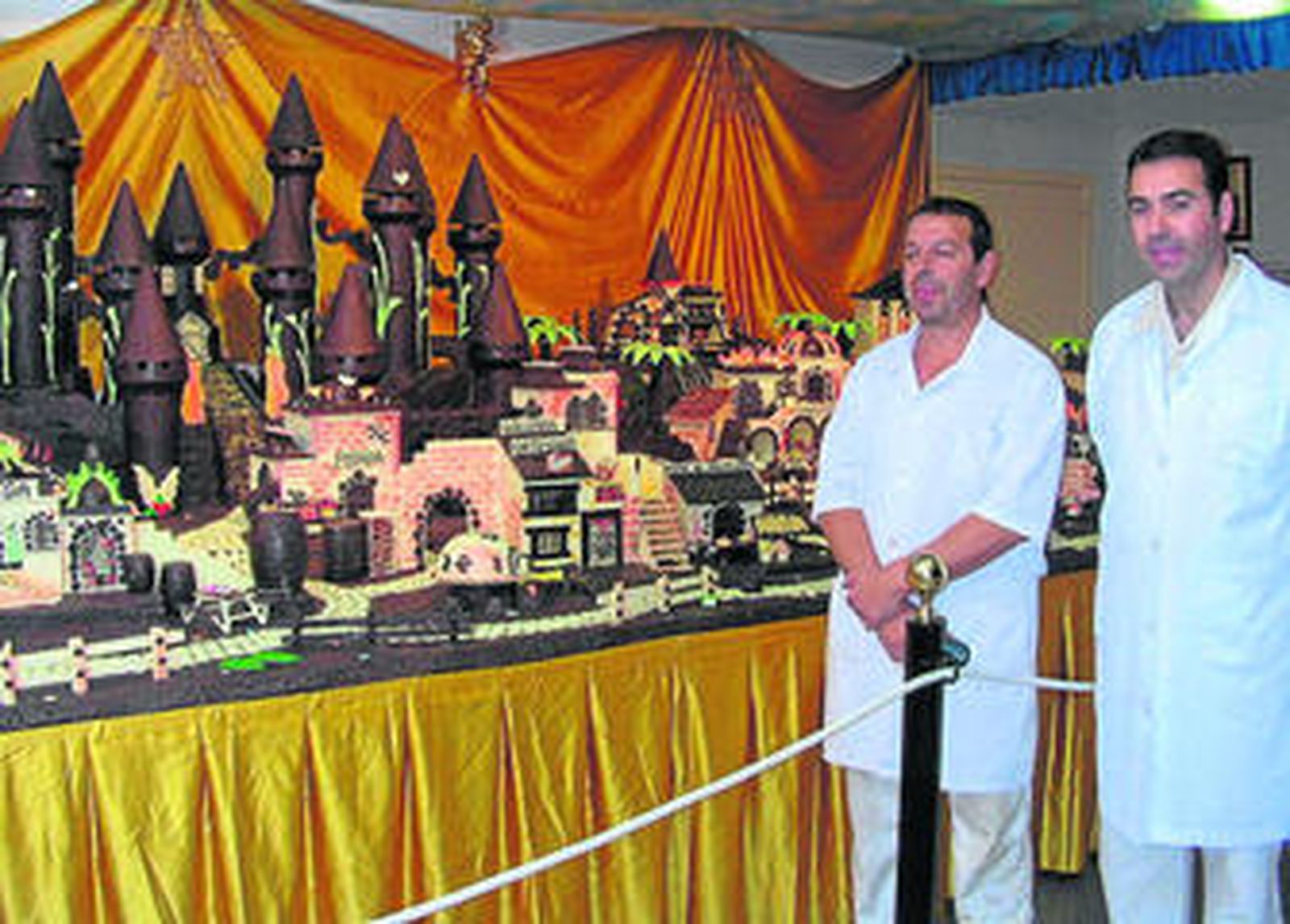 Foto de archivo de los responsables de Galleros Artesanos posando con el belén de chocolate.