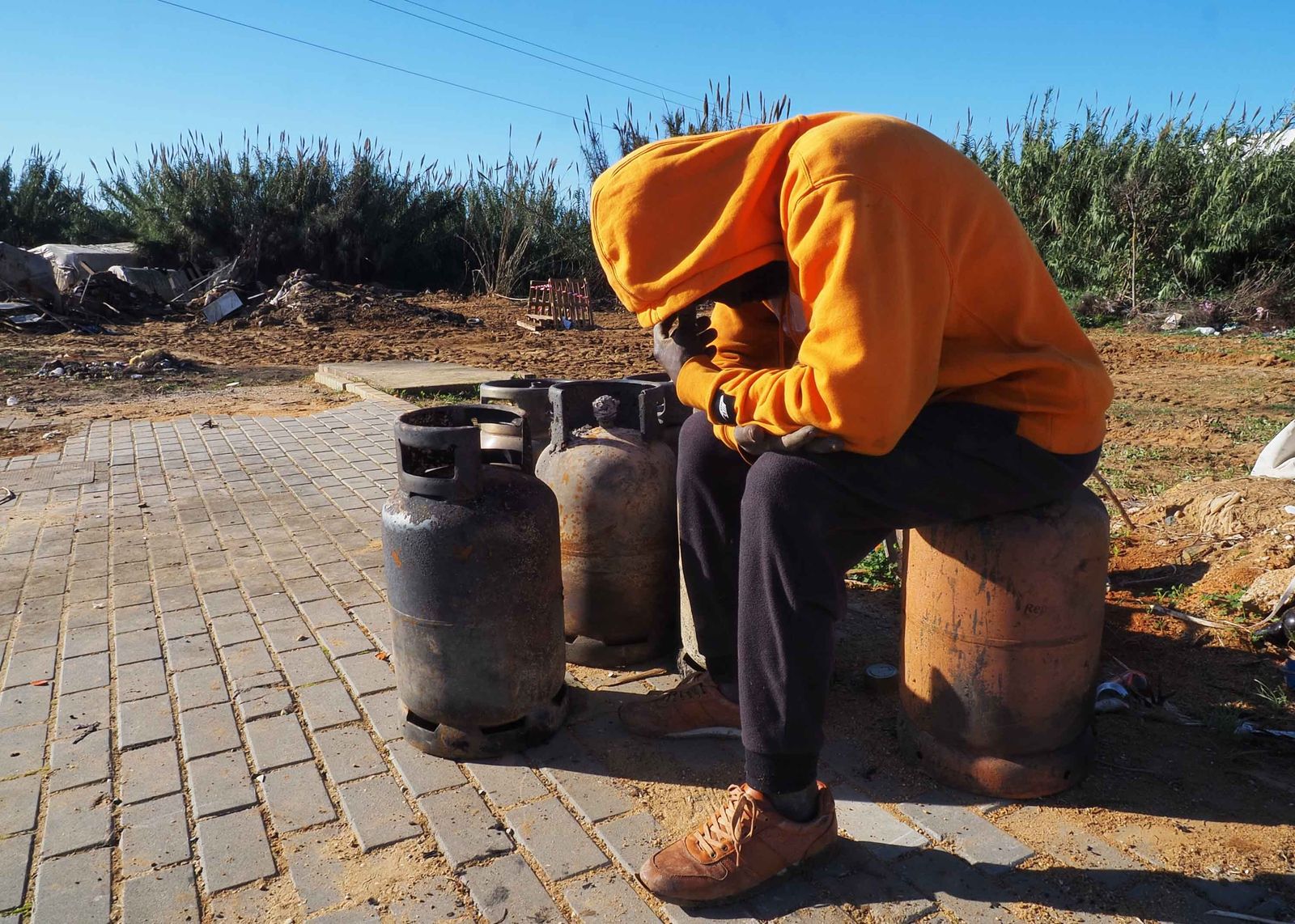 Uno de los afectados lamenta lo ocurrido sentado sobre bombonas calcinadas