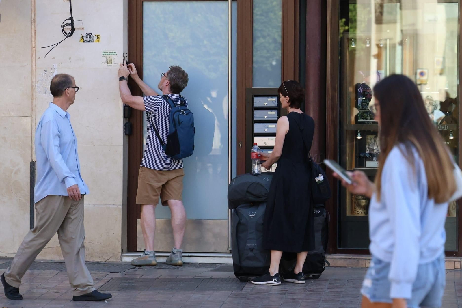 Unos turistas accediendo a un piso turístico en el centro de Málaga.