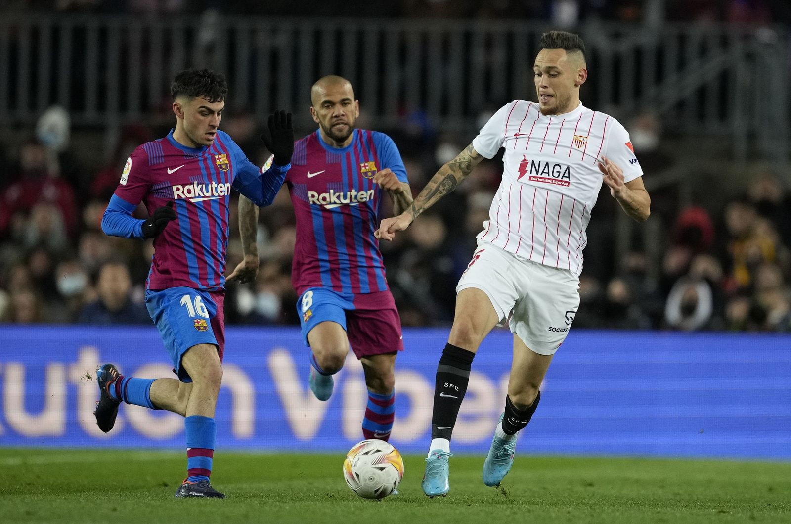 Ocampos intenta progresar ante Pedri y Daniel Alves.