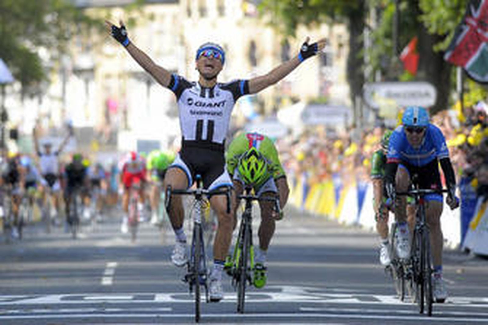 Marcel Kittel alza los brazos en señal de victoria tras cruzar la línea de meta en Harrogate y convertirse en el primer líder del Tour de Francia.