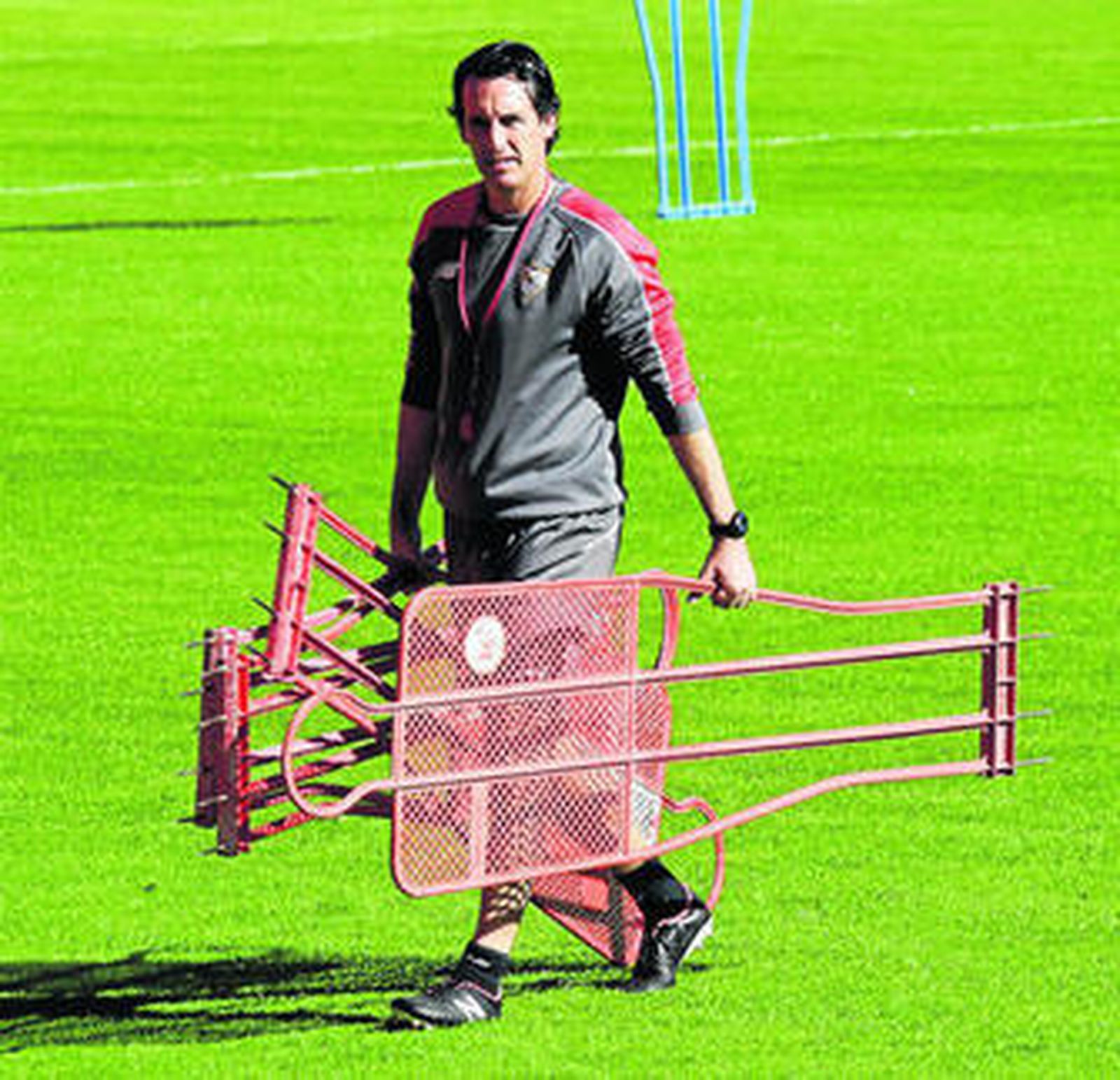 Unai Emery carga con material de entrenamiento en la sesión de ayer en el estadio.