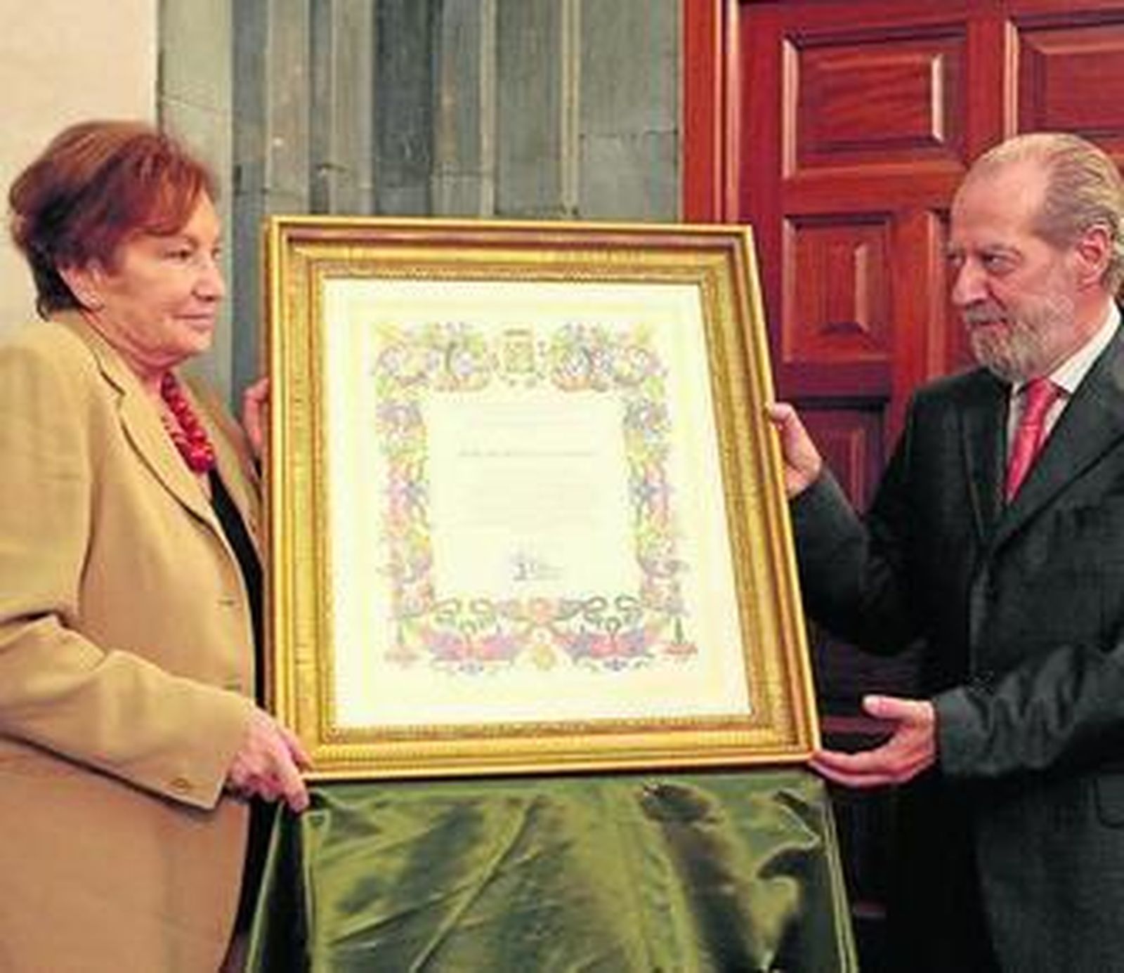 Villalobos entrega el título a Hijo Adoptivo a Rosa Pariente.