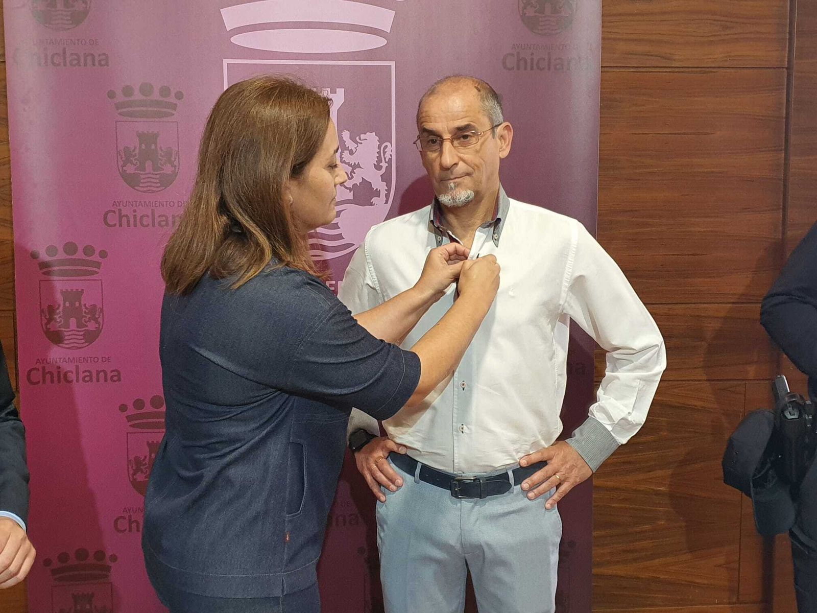 La primera teniente de alcalde coloca la Insignia del Ayuntamiento a Francisco Javier Macías Arce.