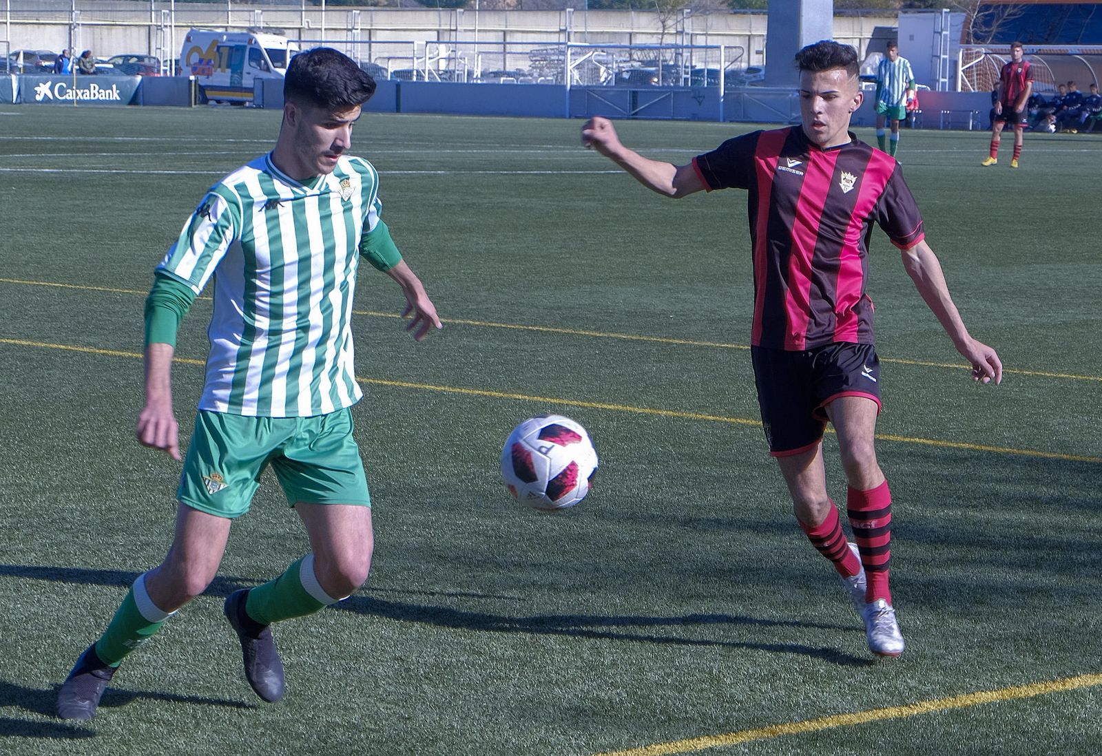 Un jugador rojinegro presiona a un jugador del Betis.