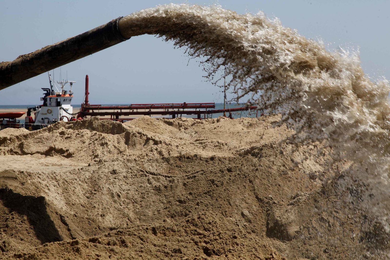 El inicio de los trabajos de regeneración de la arena en la playa de El Portil