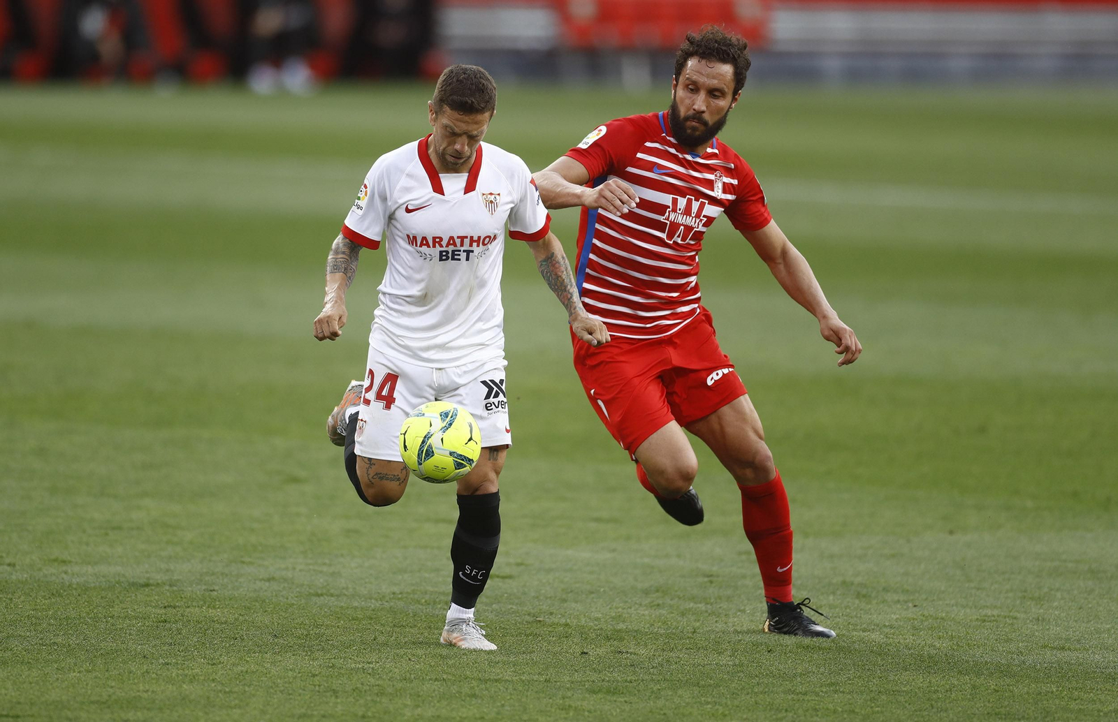 El Papu ensaya el pase de volea ante Germán en el Sevilla-Granada.