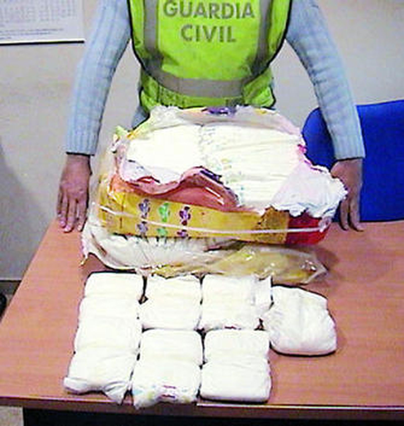 Un agente muestra los pañales en donde se encontró la droga.