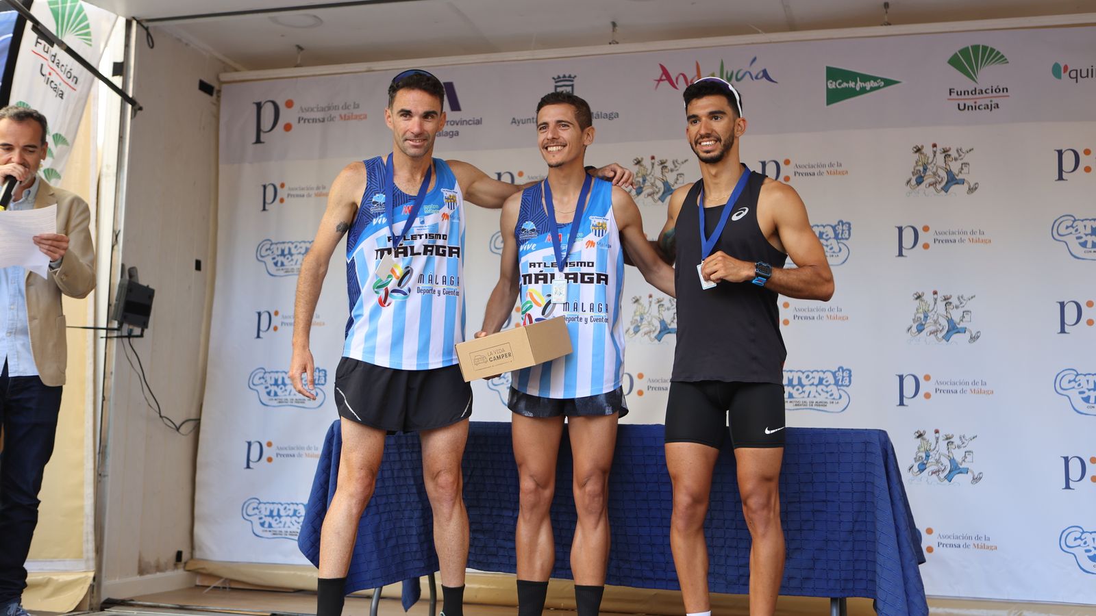 Los velocistas más rápidos de la Carrera de la Prensa posan con sus medallas.