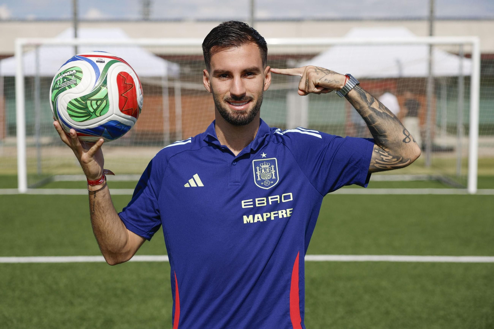 El centrocampista roquetero se señala la sien mientras sujeta un balón durante el reportaje fotográfico de su entrevista con EFE.